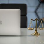 Elegant balance of technology and justice scales on an office desk.